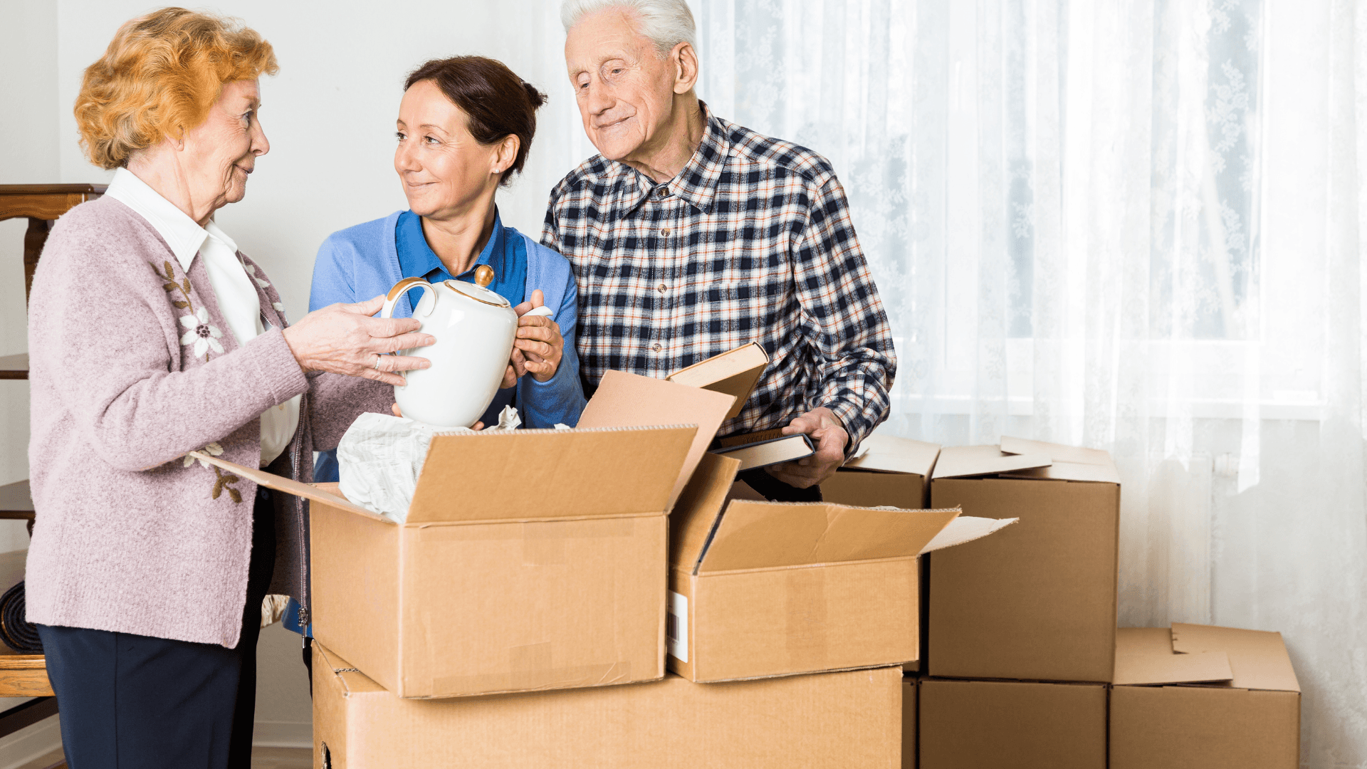 Senior couple and helper packing household items into boxes for a Salt Lake City downsizing move